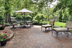 Paved backyard with patio furniture